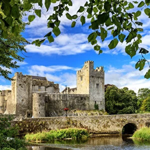 Europe, Ireland, Cahir castle and village at sunset reflecting in Caher river