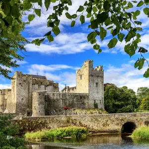 Europe, Ireland, Cahir castle and village at sunset reflecting in Caher river