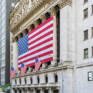 The facade of New York Stock Exchange (NYSE) building adorned with the US flag, Wall Street, Lower Manhattan, New York, USA