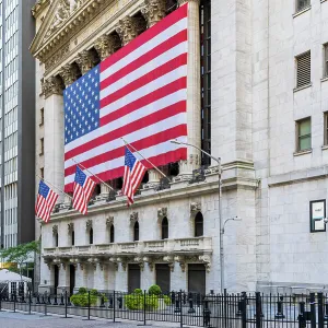 The facade of New York Stock Exchange (NYSE) building adorned with the US flag, Wall Street, Lower Manhattan, New York, USA