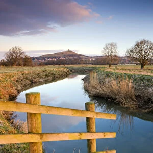 First light of morning on Glastonbury Tor viewed from the River Brue on the Somerset