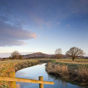 First light of morning on Glastonbury Tor viewed from the River Brue, Somerset Levels
