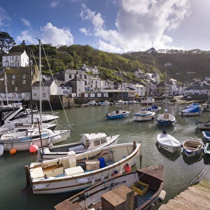 Fishing boats moored in picturesque Polperro harbour on a sunny Spring evening, Cornwall