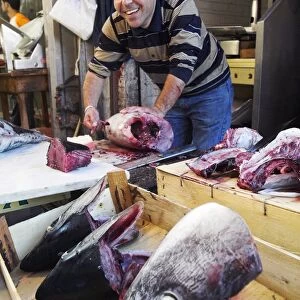 A fishmoger prepares fresh tuna