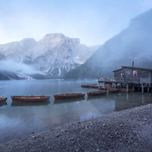A foggy late summer morning at the famous Braies lake, as the clouds were lifting and the mountains starting to reveal themselves. Dolomites, Italy