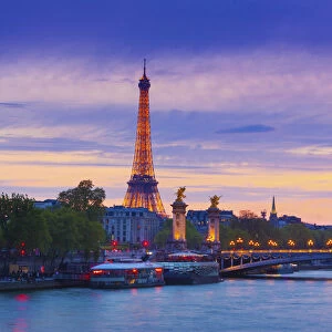 France, Paris, Eiffel Tower illuminated at night and river Seine