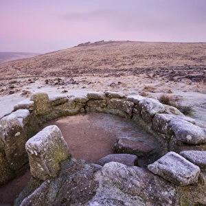 Frost coats a hut circle dwelling in the bronze age settlement of Grimspound in Dartmoor