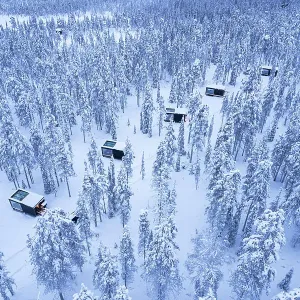 Glass cabins set on the middle of the frozen forest covered with snow at dusk, Finnish Lapland, Finland Glass cabins set on the middle of the frozen forest covered with snow at dusk, Finnish Lapland, Finland