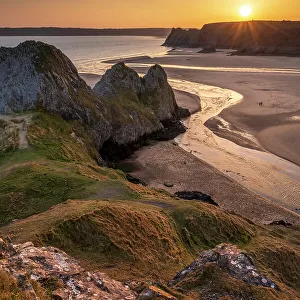 Golden sunset over Three Cliffs Bay on the Gower Peninsula, South Wales, UK. Spring (March) 2022