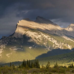 Gorgeous rich evening sunlight bathes against the towering Mount Rundle in the Canadian
