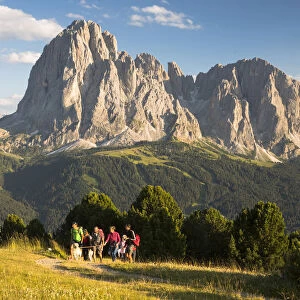 a group of hikers is walking in Val Gardena with the Langkofel and Plattkofel in the