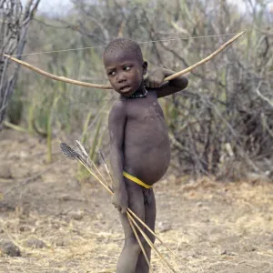 A Hadza boy carrying a bow and arrows