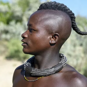 A Himba youth with his hair styled in a long plait, known as ondatu