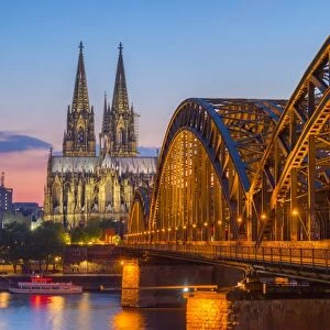 Hohenzoller Bridge over River Rhine and Cologne Cathedral at dusk in Cologne city
