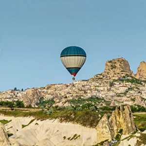 Hot air balloons at sunrise with mountain village of Ortahisar in the background