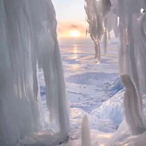 Ice stalactites in a cave at the shore at sunset at lake Baikal, Irkutsk region, Siberia
