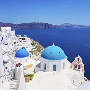Iconic blue domed churches of Resurrection of the Lord and Saint Spyridon, elevated view, Oia Village, Santorini or Thira Island, Cyclades, Greece