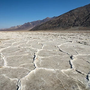 Idyllic view of salt pans by rocky mountains on sunny day, Badwater Basin
