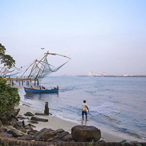 India, Kerala, Cochin - Kochi, Vipin Island, Man fishing infront of Chinese fishing nets