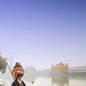 India, Punjab, Amritsar, a sikh pilgrim carrying a barcha spear at the Golden Temple