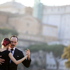 Italy, Rome, tango dancers at Roman Forum with Altare della Patria in the background