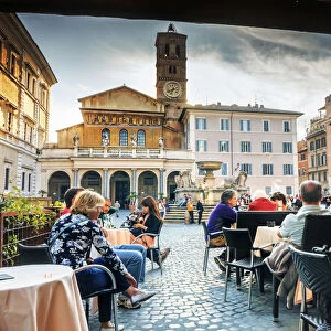 Italy, Rome, tourists having lunch in a restaurant in front of Santa Maria in Trastevere