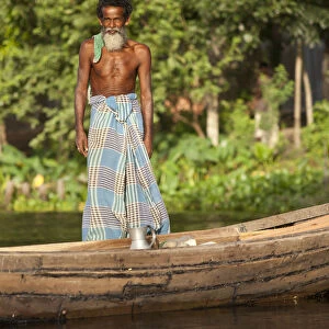 Jessore, Bangladesh. A traditional boatman transports milk to market