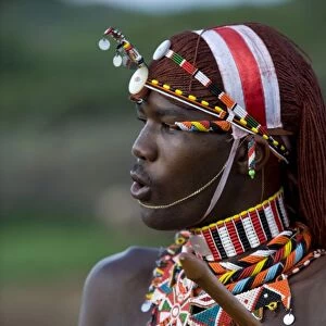 Kenya, Laikipia, Ol Malo. A Samburu warrior sings and claps during a dance