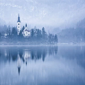 Lake Bled at dawn in winter with Assumption of Marys Pilgrimage Church, Slovenia