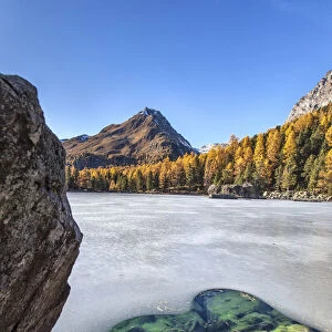 Lake Saoseo in the Poschiavo Valley almost completely frozen amid the autumn colors