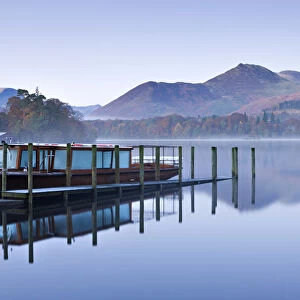 Lakeland Mist pleasure boat moored on a placid Derwent Water on a misty and frosty