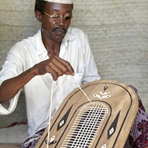 A Lamu man strings the back of a traditional Lamu-style