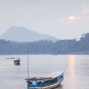Laos, Luang Prabang, Riverboats on the Mekong River, sunset