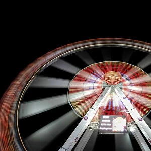Long exposure of illuminated ferris wheel at Hamburger DOM funfair at night, St. Pauli