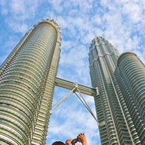 Malaysia, Kuala Lumpur, Petronas Towers, Woman photographing towers MR