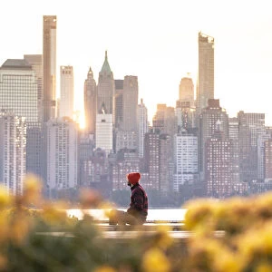 A man admiring Manhattan skyline at sunrise, New York, USA