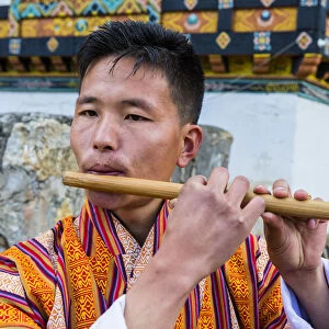A man playing the flute at a local festival in Paro District, Bhutan