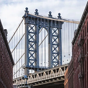 Manhattan bridge structure framing the Empire State building, Brooklyn, New York, USA