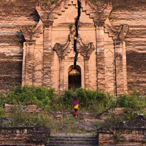 Mingun, Sagaing region, Myanmar (Burma). Woman with red umbrella climbs the stairs