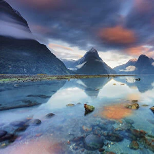 Mitre Peak reflecting in the fjord water at sunrise at Milford Sound in New Zealand