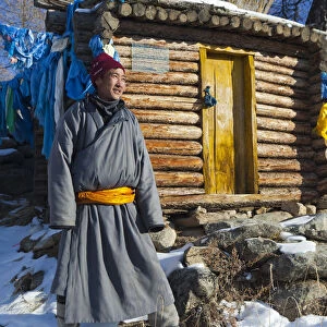 Mongolia, Ovorkhangai, Orkhon Valley. A Mongolian man stands by a hut at hot springs