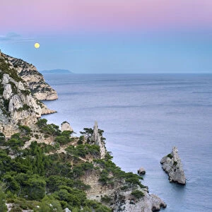 Full moon rising over ocean and Mediterranean landscape at Calanque de Sugiton after