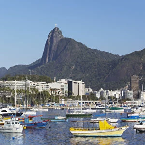 Moored boats in harbour with Christ the Redeemer statue in background, Urca, Rio de