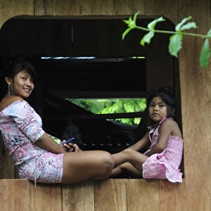 Mother and child sat on window, Ticuna Indian Village of Macedonia, Amazon River
