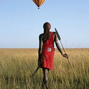 A Msai Warrior watches a hot air balloon float over the Mara plains