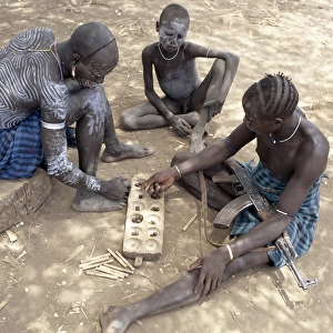 Two Mursi men with singular hairstyles play a game