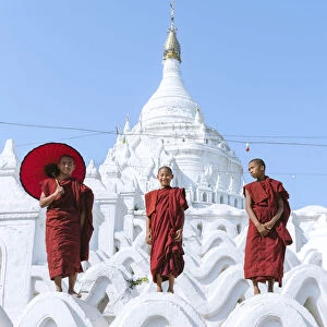 Myanmar, Mandalay division, Mingun. Three novice buddhist monks standing on Hsinbyume