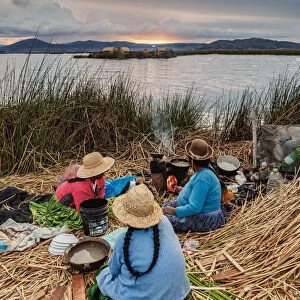 Native Uro Family preparing a meal, Uros Floating Islands, Lake Titicaca, Puno Region
