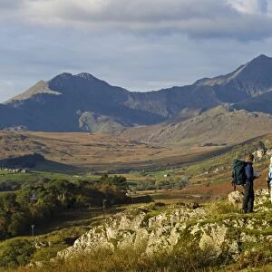 North Wales, Snowdonia. A man and woman stop to look at their map whilst hiking in Snowdonia