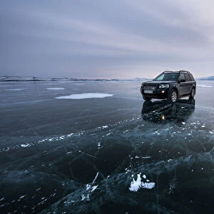 An offroad car over a flat ice at the lake Baikal, Irkutsk region, Siberia, Russia
